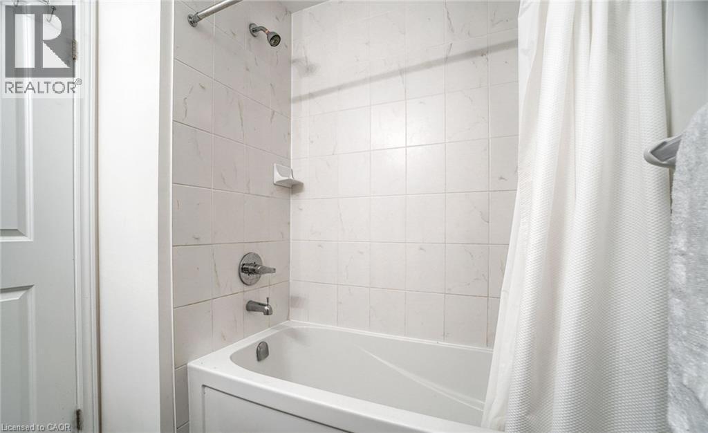 Bathtub and shower combination featuring white tiled surround - 14 Faye Street, Brampton, ON - Indoor Photo Showing Bathroom
