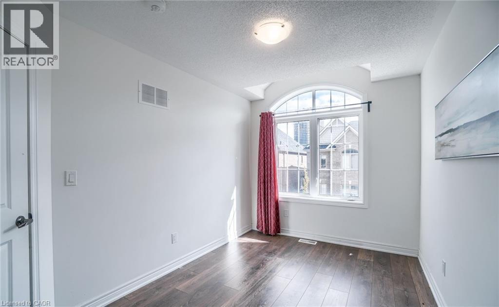 Arched window with gridded panes and a white frame - 14 Faye Street, Brampton, ON - Indoor Photo Showing Other Room