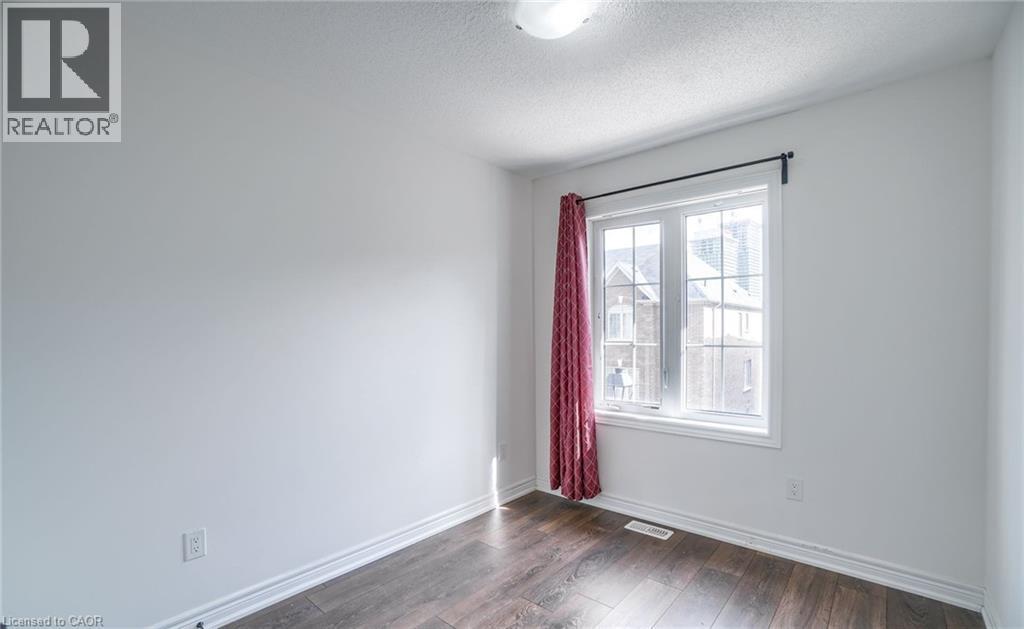 Room featuring wood-finish flooring, white baseboards, and neutral wall paint - 14 Faye Street, Brampton, ON - Indoor Photo Showing Other Room