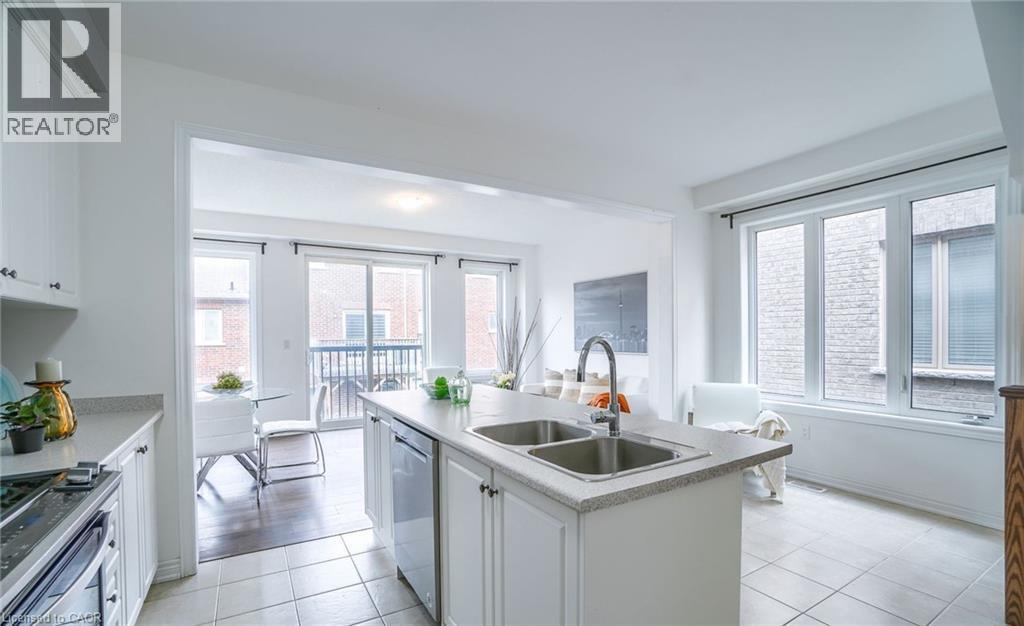 Open-concept kitchen featuring white cabinetry, a double basin sink, and tile flooring - 14 Faye Street, Brampton, ON - Indoor Photo Showing Kitchen With Double Sink With Upgraded Kitchen