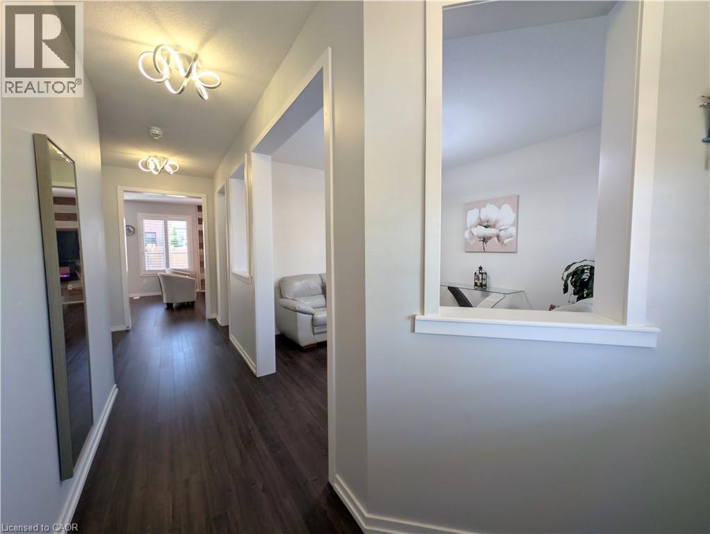 Hallway featuring dark wood-finish flooring, white baseboards, and contemporary ceiling light fixtures - 37 Mull Avenue, Caledonia, ON - Indoor Photo Showing Other Room