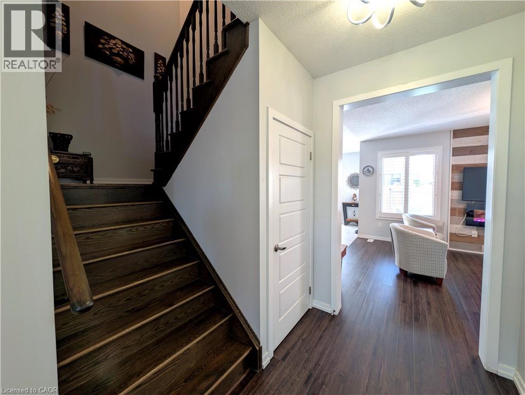 Dark wood-finish flooring extending through the entry and into an open living area - 37 Mull Avenue, Caledonia, ON - Indoor Photo Showing Other Room