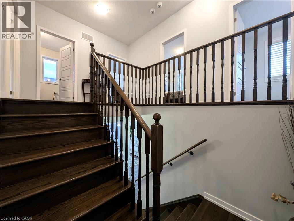 Dark wood-finish stairs with matching balusters and handrails - 37 Mull Avenue, Caledonia, ON - Indoor Photo Showing Other Room