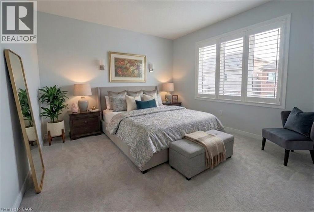 Soft gray wall color with recessed lighting, plush carpet flooring, and a large window with white plantation shutters - 37 Mull Avenue, Caledonia, ON - Indoor Photo Showing Bedroom