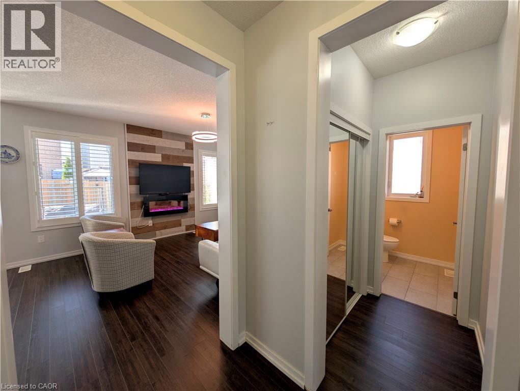 Living space featuring dark wood-finish flooring and a wood-panel accent wall - 37 Mull Avenue, Caledonia, ON - Indoor