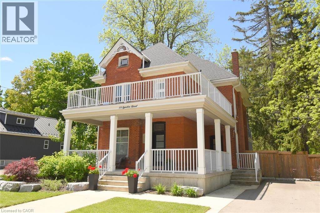 Red brick exterior with a prominent two-story balcony featuring white railings - 89 Lynden Road, Lynden, ON - Outdoor With Balcony With Deck Patio Veranda