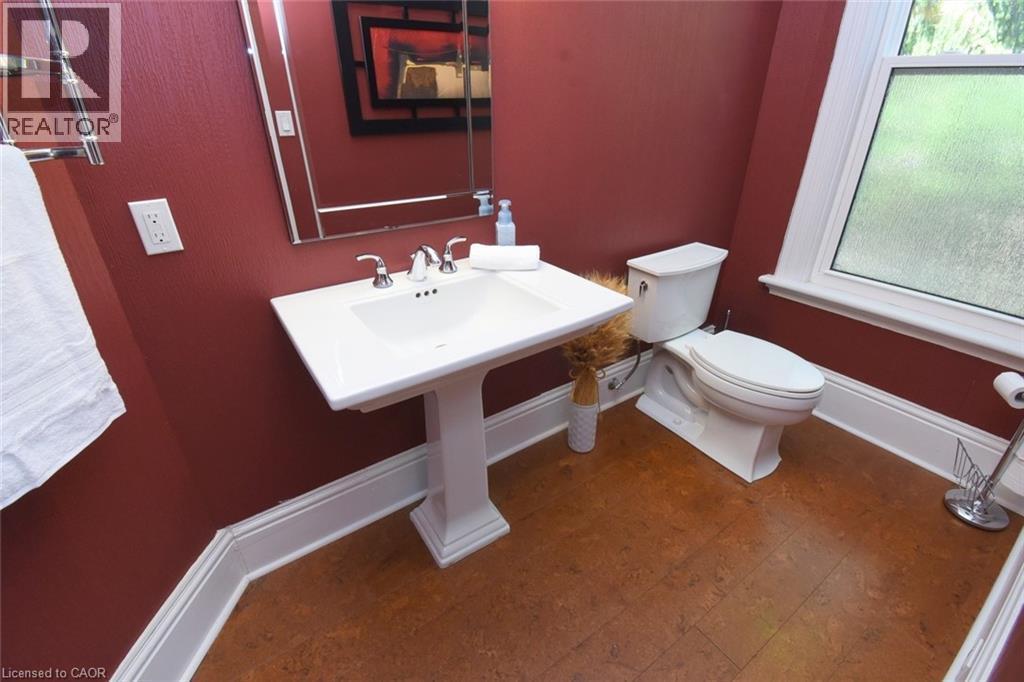 Pedestal sink with chrome fixtures and a beveled mirror - 89 Lynden Road, Lynden, ON