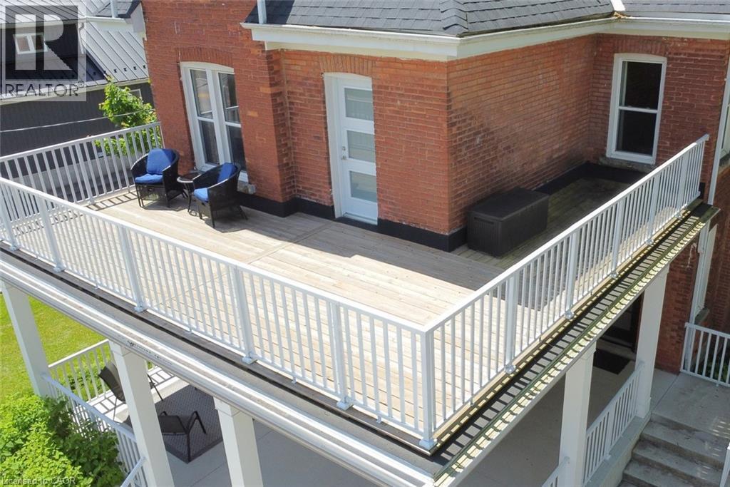 Expansive upper-level deck featuring white railing, white exterior door and white railings - 89 Lynden Road, Lynden, ON