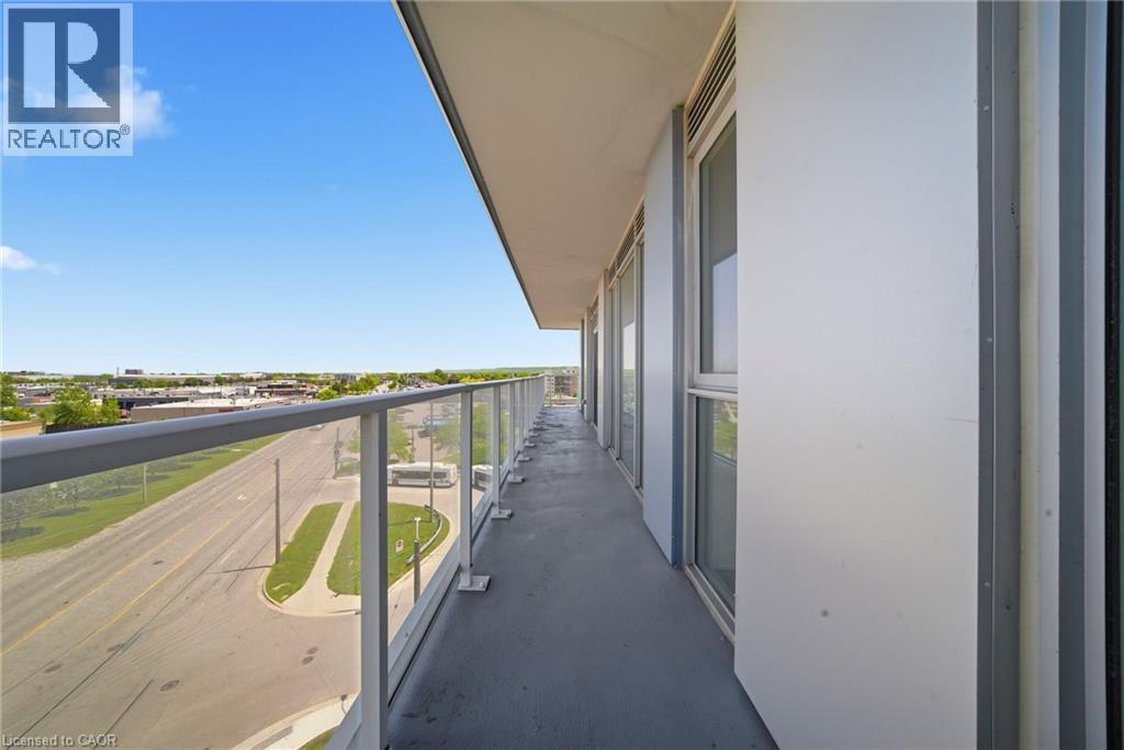 Spacious private balcony featuring a glass panel railing, concrete flooring, and multiple exterior windows - 2782 Barton Street E Unit# 516, Hamilton, ON - Outdoor With Balcony With View With Exterior