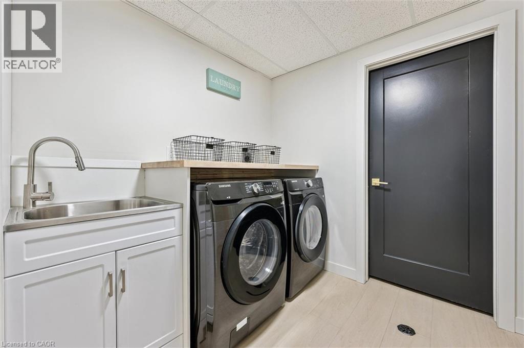 Laundry area featuring a drop ceiling, washing machine and clothes dryer, and light wood-style flooring - 459 Drummerhill Crescent, Waterloo, ON - Indoor Photo Showing Laundry Room