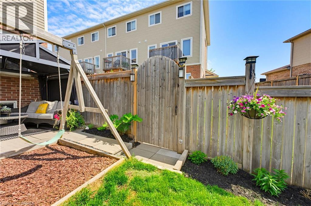 Private backyard featuring a paved patio area, an arched wooden gate, and perimeter fencing - 100 Chester Drive Unit# 16, Cambridge, ON - Outdoor With Exterior