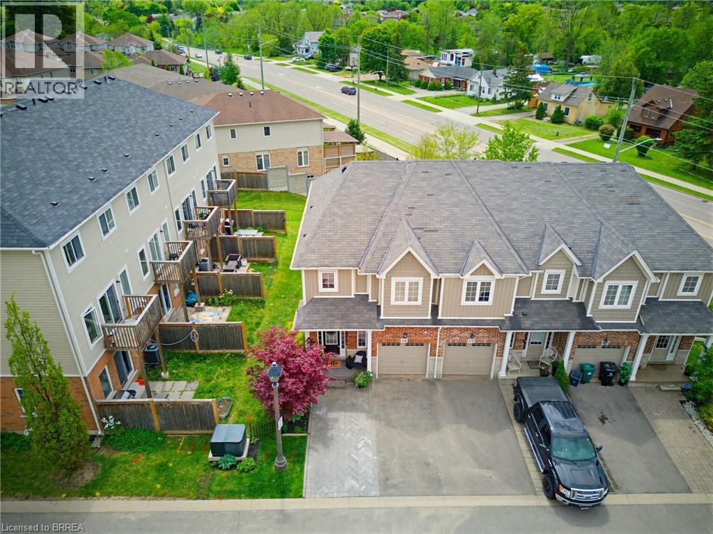 Townhome exterior with brick and siding facade, featuring gabled roofs and individual garage doors - 100 Chester Drive Unit# 16, Cambridge, ON - Outdoor