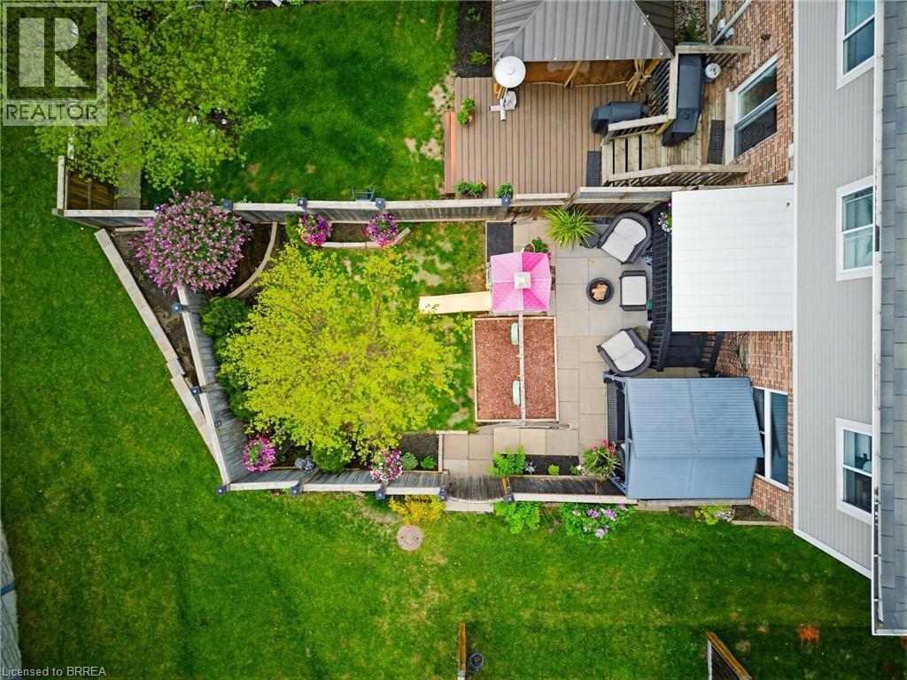 Multi-level outdoor living space featuring a wood-finish deck, an adjacent stone paver patio, and a separate ground-level patio area - 100 Chester Drive Unit# 16, Cambridge, ON - Outdoor