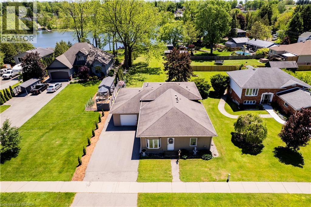 Single-story residence featuring a front lawn and paved driveway - 100 Mechanic Street W, Waterford, ON - Outdoor