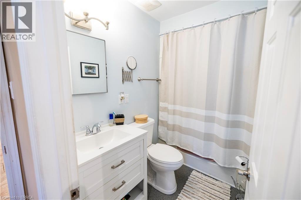 Bathroom featuring a white vanity with integrated sink, chrome faucet, and rectangular mirror - 100 Mechanic Street W, Waterford, ON - Indoor Photo Showing Bathroom