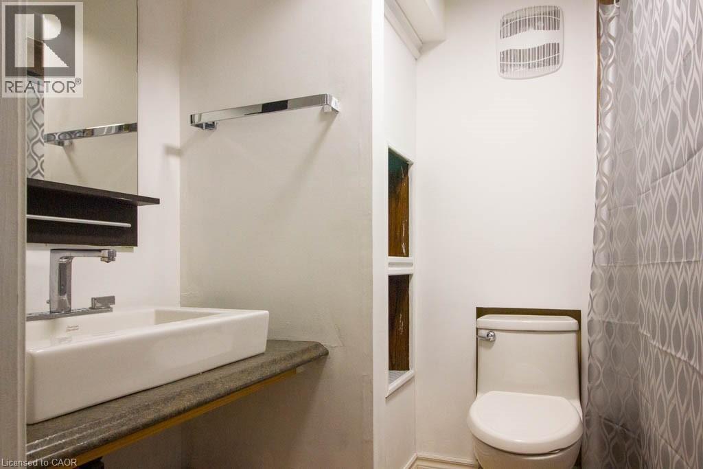 Contemporary bathroom featuring a rectangular vessel sink, wall-mounted faucet, and a wall-mounted mirror - 30 Eastvale Place, Hamilton, ON - Indoor Photo Showing Bathroom
