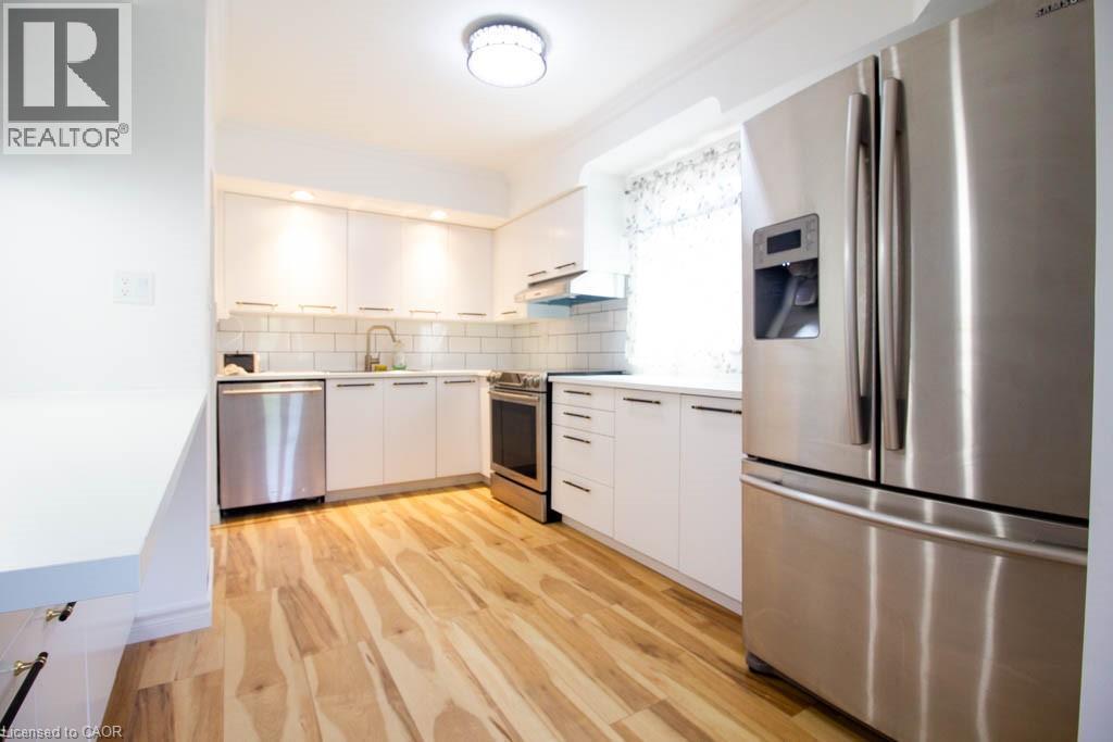 Modern kitchen featuring light wood-finish flooring and white cabinetry - 30 Eastvale Place, Hamilton, ON - Indoor Photo Showing Kitchen