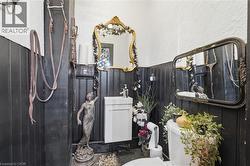 Bathroom featuring black wainscoting and white textured walls -