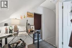 Sloped ceiling room featuring white painted walls and a dark red accent wall -