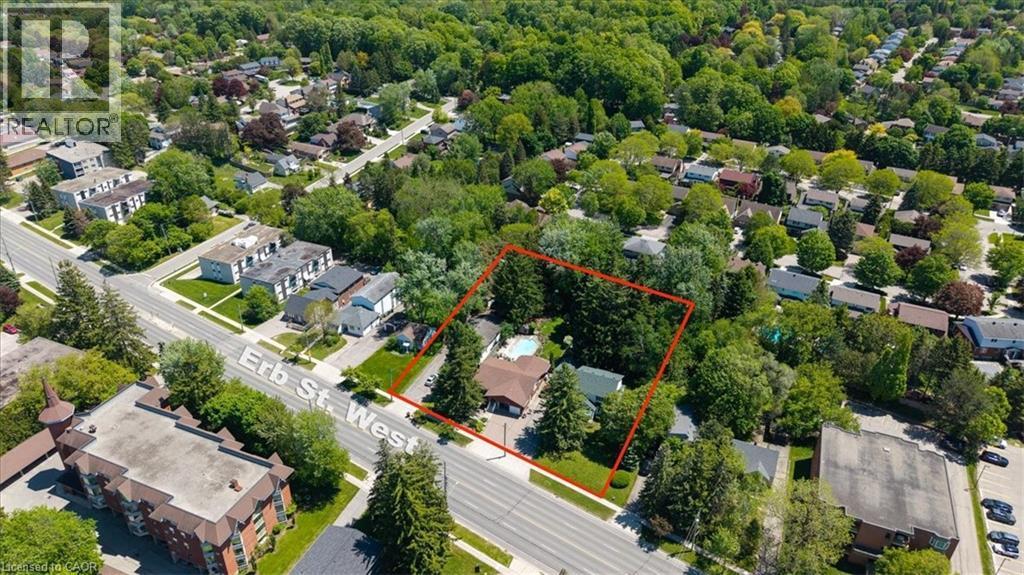 Aerial property with mature trees, a private backyard pool, and road frontage - 391 Erb Street, Waterloo, ON