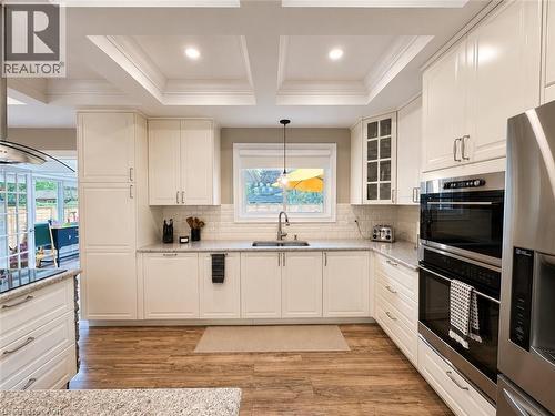 Gourmet kitchen featuring white shaker cabinetry, stainless steel double wall ovens, wood-finish flooring, recessed lighting, and a subway tile backsplash - 107 Rosslinn Road, Cambridge, ON - Indoor Photo Showing Kitchen With Double Sink With Upgraded Kitchen