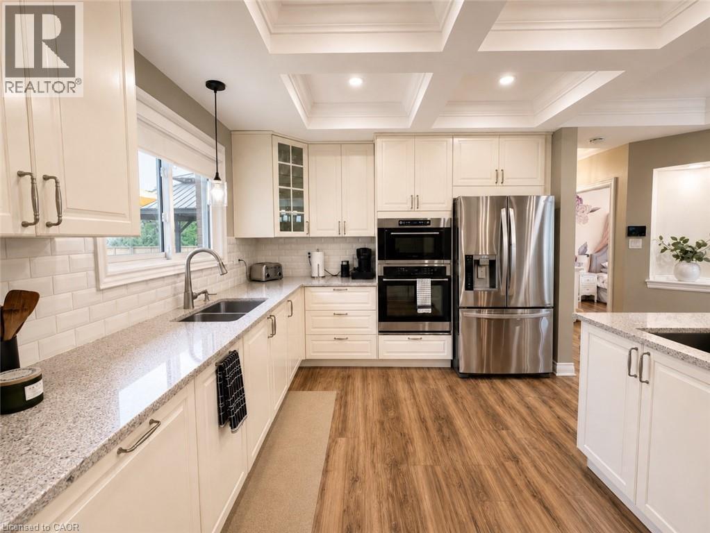 Kitchen featuring white cabinetry, stainless steel appliances, a white subway tile backsplash, and light-toned countertops. - 107 Rosslinn Road, Cambridge, ON - Indoor Photo Showing Kitchen With Double Sink With Upgraded Kitchen