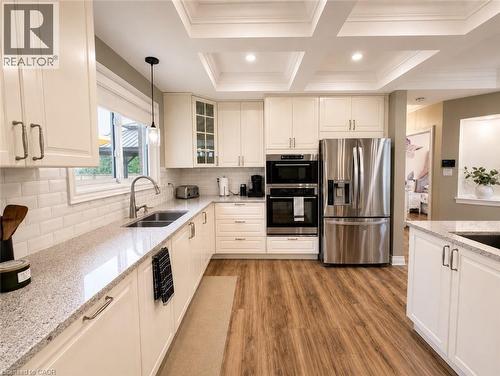 Kitchen featuring white cabinetry, stainless steel appliances, a white subway tile backsplash, and light-toned countertops. - 107 Rosslinn Road, Cambridge, ON - Indoor Photo Showing Kitchen With Double Sink With Upgraded Kitchen