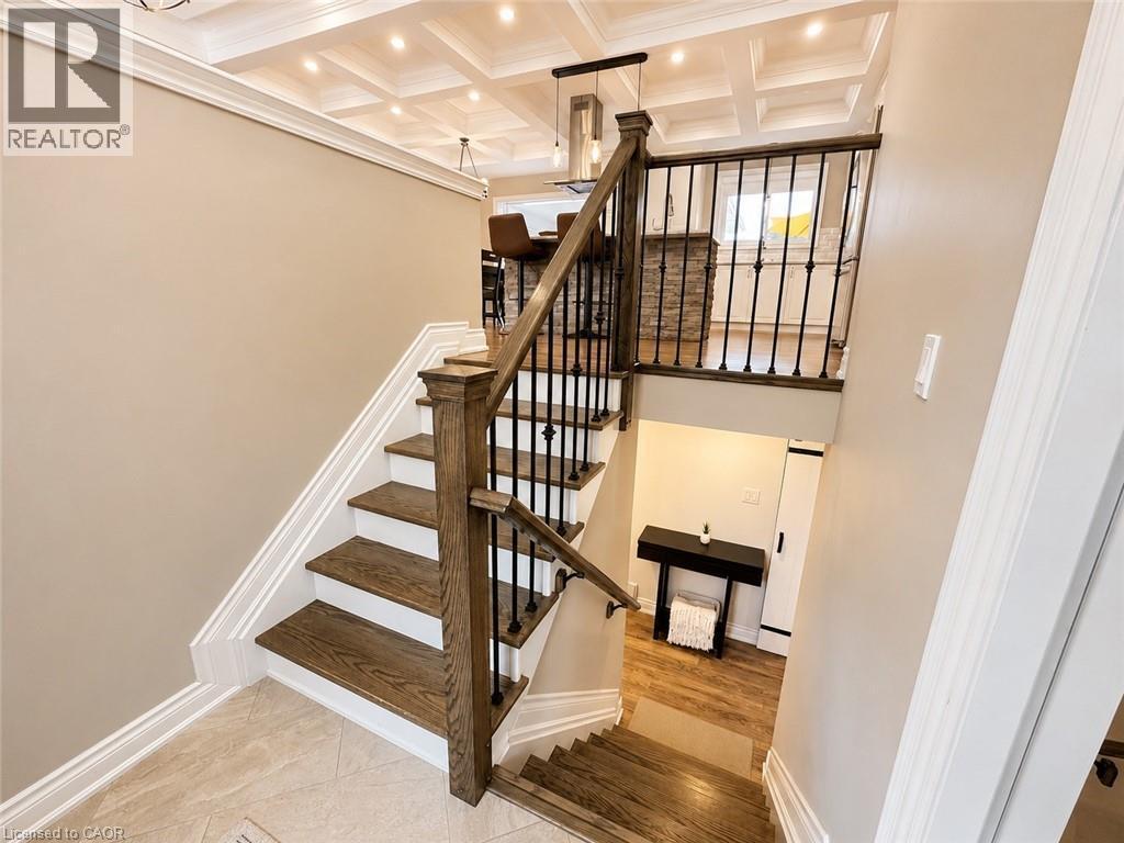 Two-story entryway featuring wood-finish stairs with white risers and decorative black metal balusters - 107 Rosslinn Road, Cambridge, ON - Indoor Photo Showing Other Room