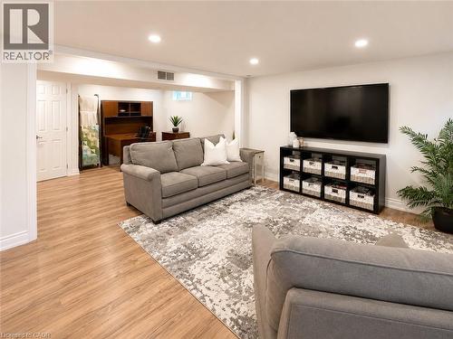 Open concept lower level featuring light wood-finish flooring, recessed lighting, white trim, and a built-in wall unit - 107 Rosslinn Road, Cambridge, ON - Indoor