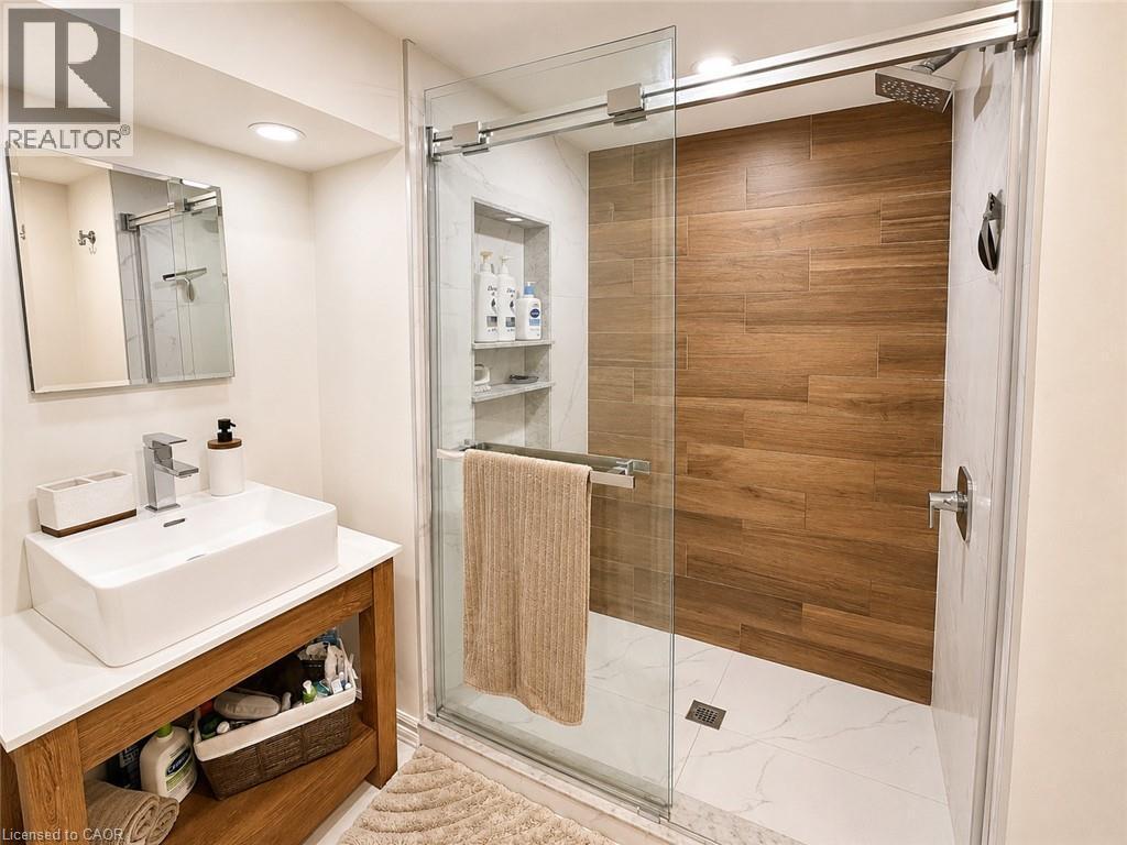 Contemporary bathroom featuring a spacious glass-enclosed shower with wood-finish wall tiling and white marble-look floor tiling - 107 Rosslinn Road, Cambridge, ON - Indoor Photo Showing Bathroom