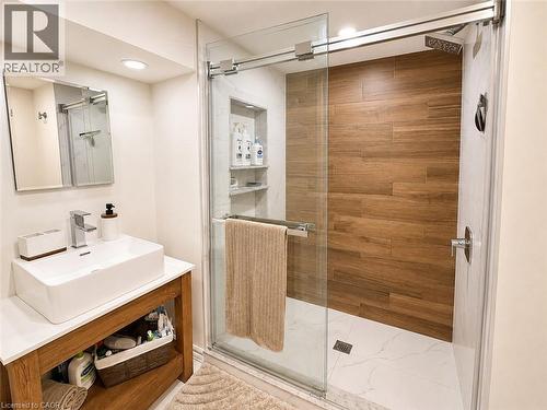 Contemporary bathroom featuring a spacious glass-enclosed shower with wood-finish wall tiling and white marble-look floor tiling - 107 Rosslinn Road, Cambridge, ON - Indoor Photo Showing Bathroom