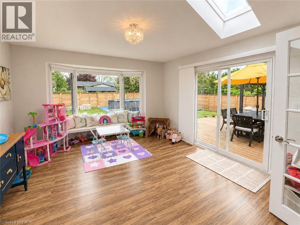 Spacious room featuring wood-finish flooring, a built-in window bench, and an overhead lighting fixture - 107 Rosslinn Road, Cambridge, ON - Indoor Photo Showing Other Room