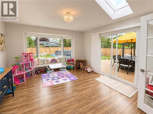 Spacious room featuring wood-finish flooring, a built-in window bench, and an overhead lighting fixture - 107 Rosslinn Road, Cambridge, ON - Indoor Photo Showing Other Room