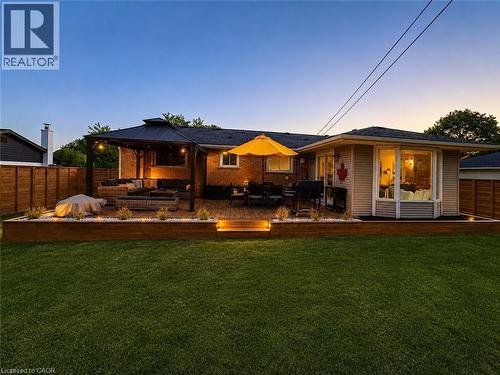Expansive backyard featuring a multi-level wood deck, a covered gazebo with string lighting, and a raised planter with landscape lighting - 107 Rosslinn Road, Cambridge, ON - Outdoor With Deck Patio Veranda