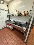Stainless steel double-basin sink with integrated countertop and shelving -