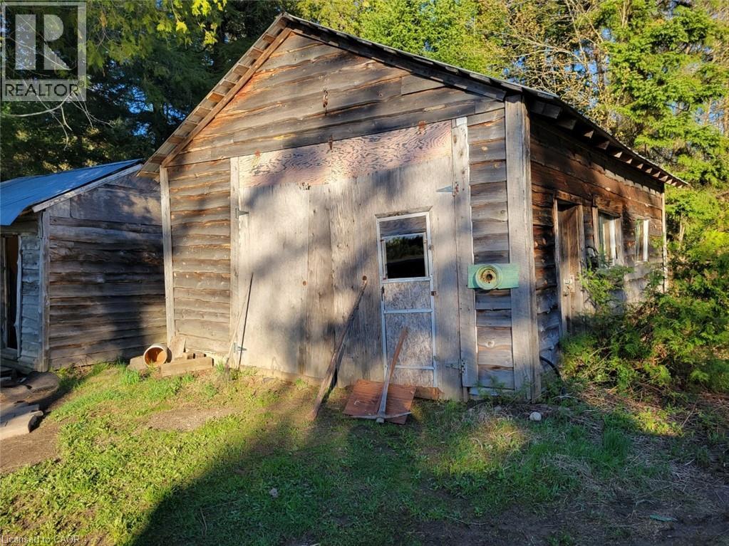 Rustic outbuilding featuring weathered wood siding, an attached screened door, and a second structure with a metal roof - 1006 Hurdville Road, Mckellar, ON - Outdoor