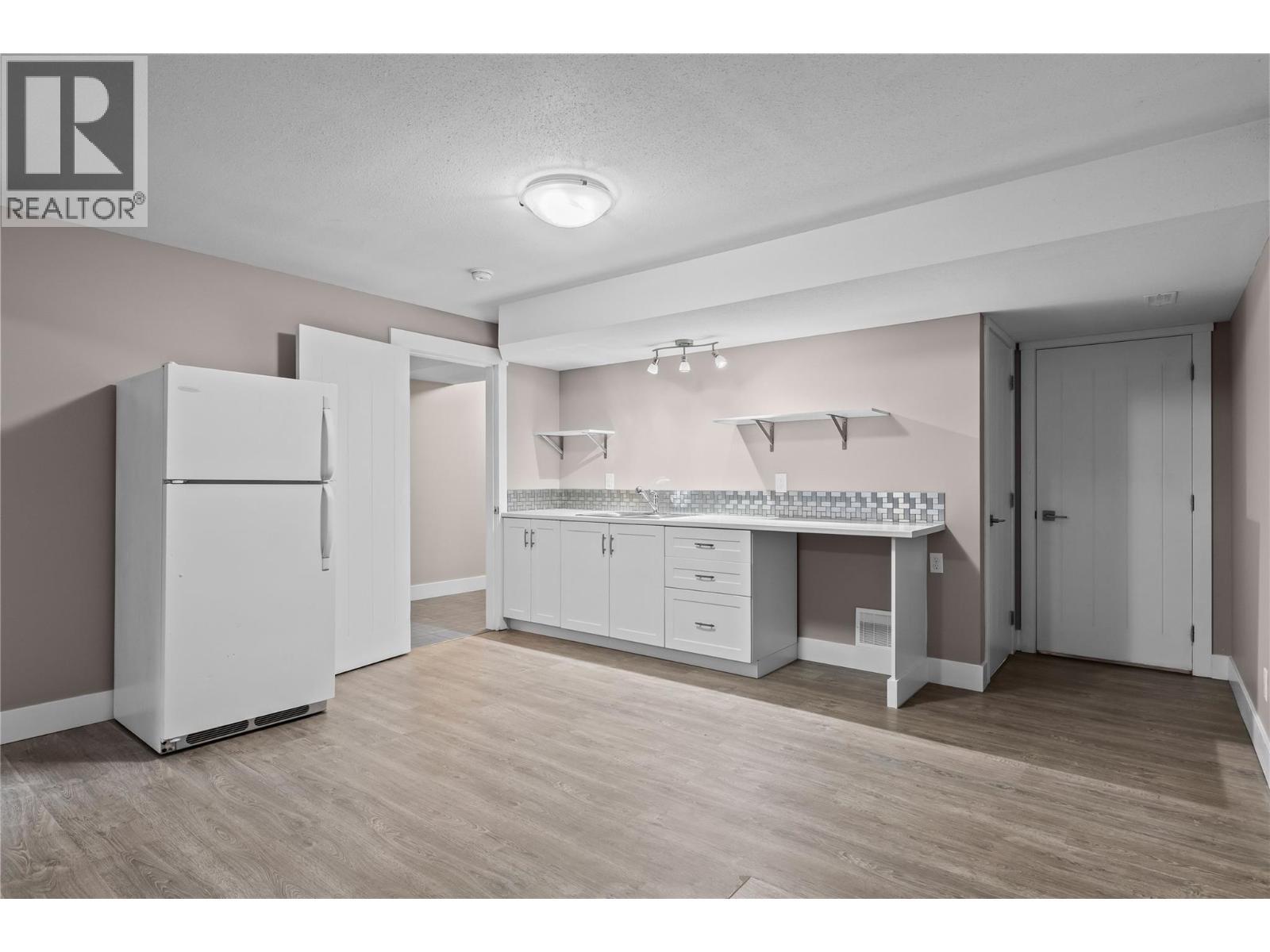 Kitchen, Dining Space with Fridge, Built-Ins and Double Sink - 827 Juniper Road, Kelowna, BC - Indoor Photo Showing Kitchen