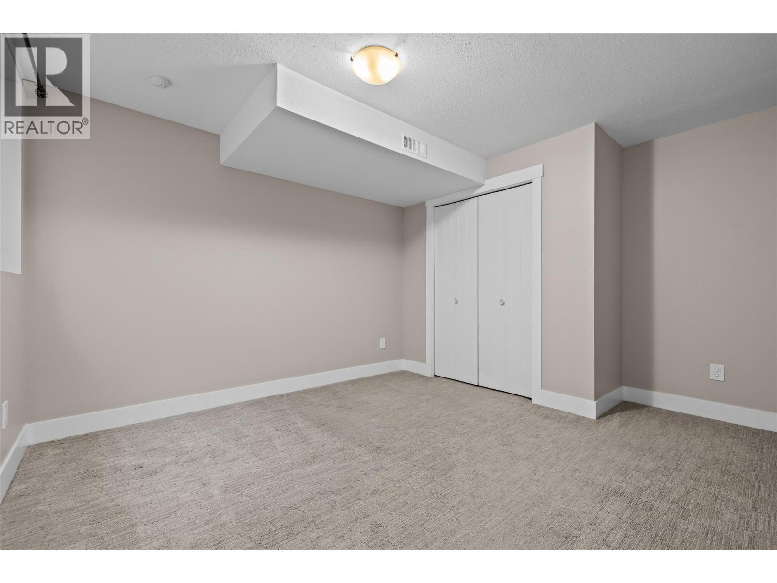 Large Bedroom with Closet and Window - 827 Juniper Road, Kelowna, BC - Indoor Photo Showing Other Room