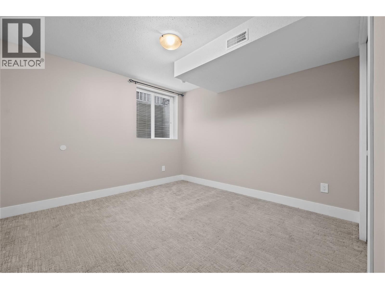 Large Bedroom with Window Egress - 827 Juniper Road, Kelowna, BC - Indoor Photo Showing Other Room