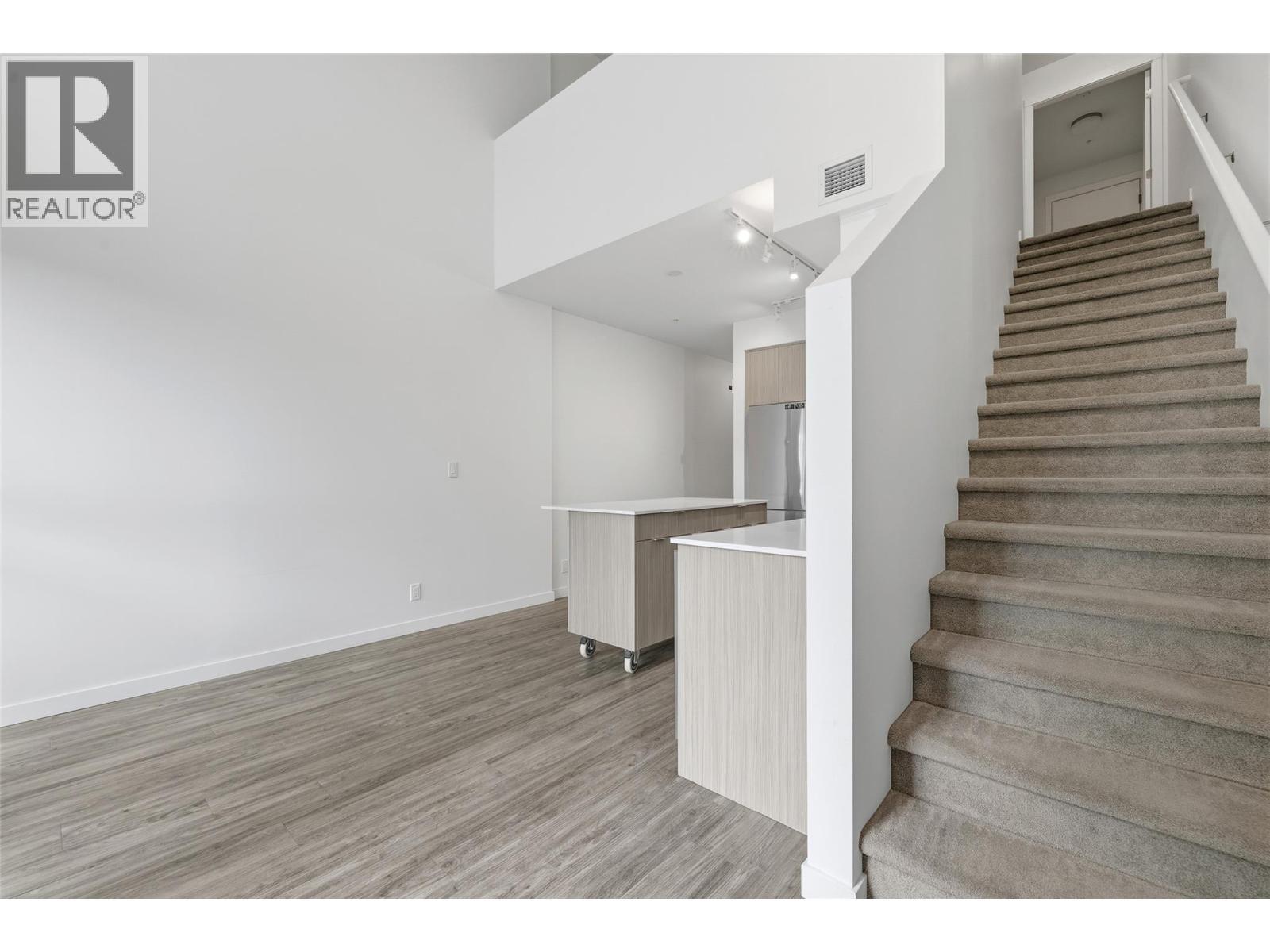 Architectural staircase leading to the private loft-style primary retreat. - 1775 Chapman Place Unit# 101, Kelowna, BC - Indoor Photo Showing Other Room