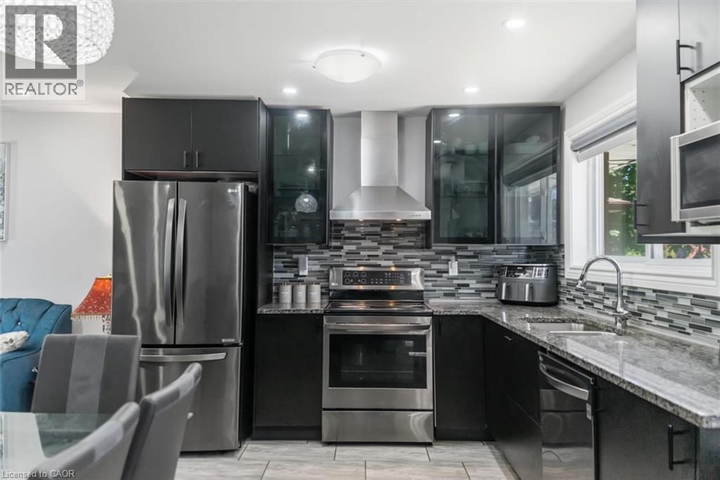 Contemporary kitchen with dark cabinetry, stainless steel appliances, and a mosaic tile backsplash - 158 Plymouth Road, Kitchener, ON - Indoor Photo Showing Kitchen With Stainless Steel Kitchen With Upgraded Kitchen