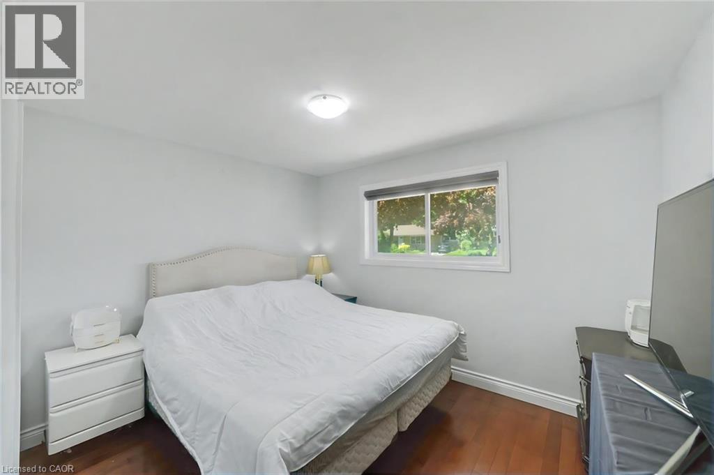 Bedroom featuring wood-finish flooring, light gray walls, a ceiling-mounted light fixture, and a window with blinds - 158 Plymouth Road, Kitchener, ON - Indoor Photo Showing Bedroom