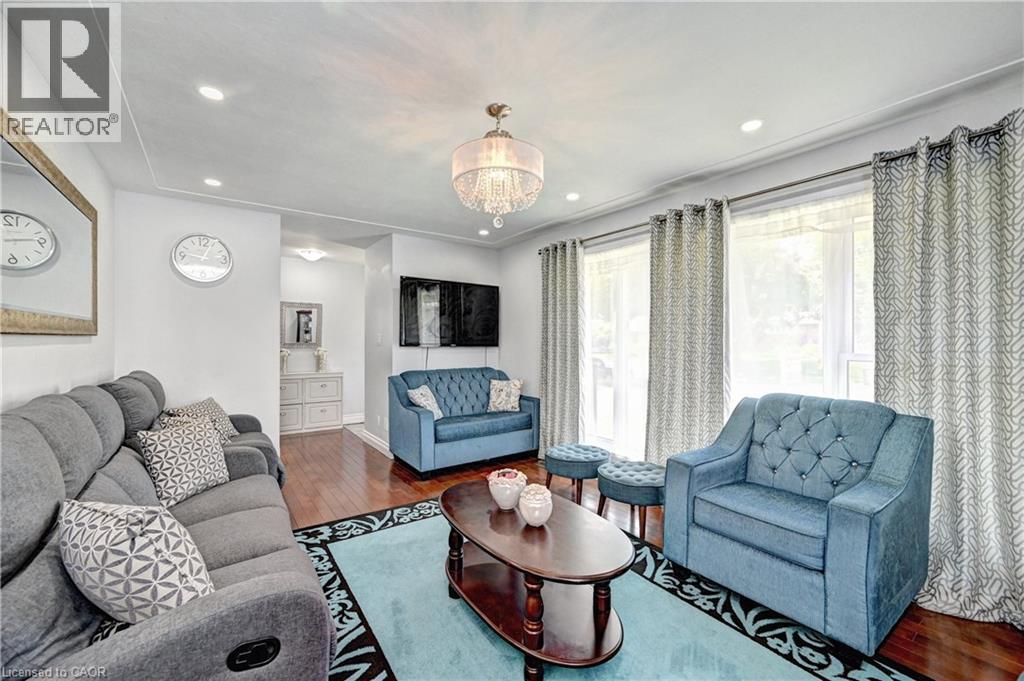 Living area featuring wood-finish flooring, recessed lighting, and a decorative chandelier - 158 Plymouth Road, Kitchener, ON