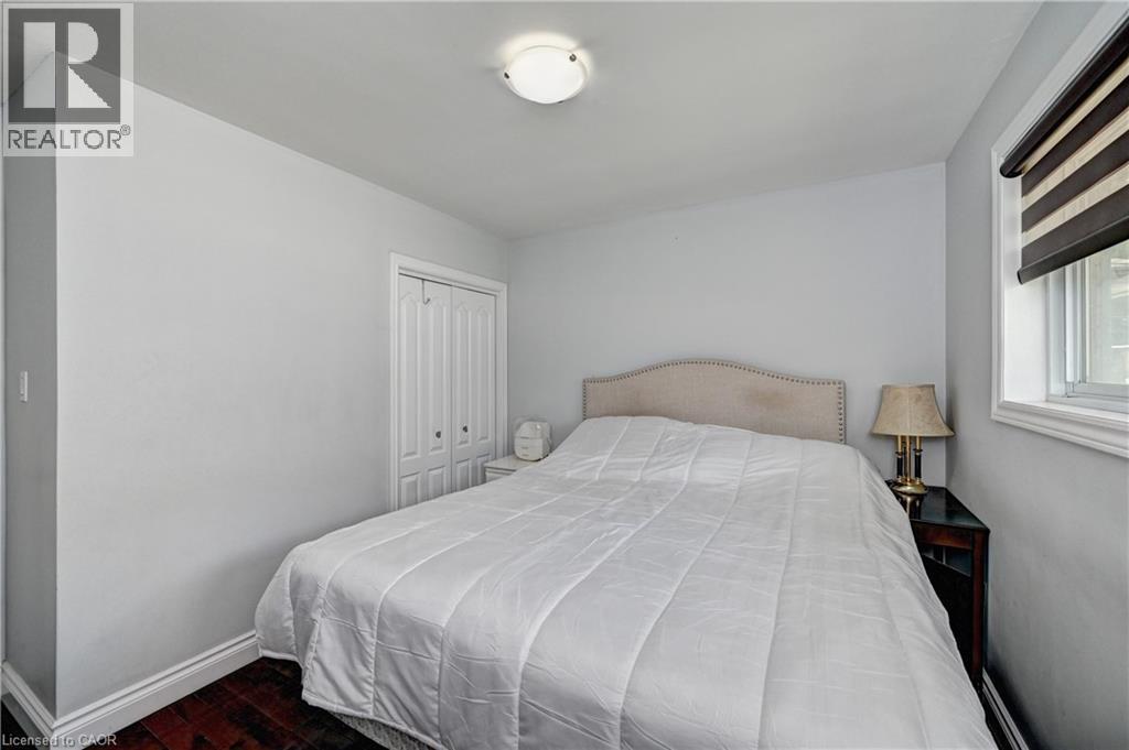 Interior room featuring wood-finish flooring, light-toned walls, and a window with a roller shade - 158 Plymouth Road, Kitchener, ON