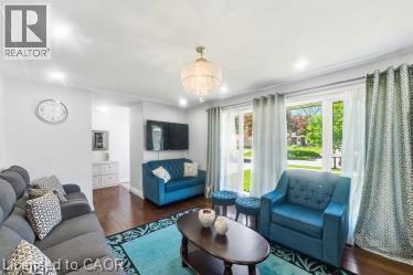 Bright living area featuring wood-finish flooring, recessed lighting, and a prominent chandelier - 158 Plymouth Road, Kitchener, ON - Indoor Photo Showing Living Room