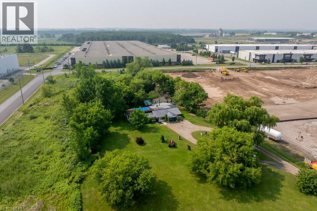 Expansive property featuring a curved driveway, mature trees, manicured lawn areas, and a single-story dwelling with a dark roof - 1264 Parkinson Road, Woodstock, ON
