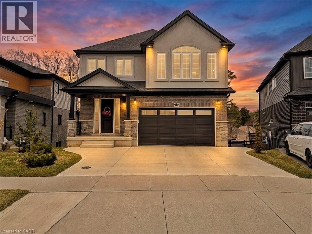 Contemporary two-story residence featuring a stucco and stone exterior, a covered front porch, and a double-door garage - 63 Ian Ormston Drive, Kitchener, ON - Outdoor