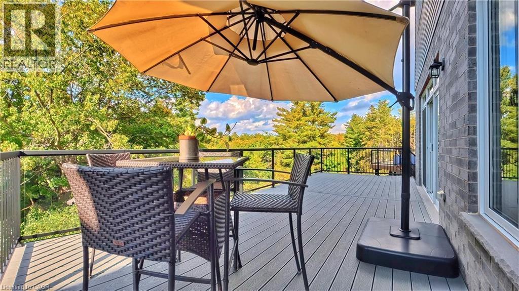 Spacious exterior deck featuring composite flooring, black metal railings, and a brick exterior wall - 63 Ian Ormston Drive, Kitchener, ON - Outdoor With Deck Patio Veranda With Exterior