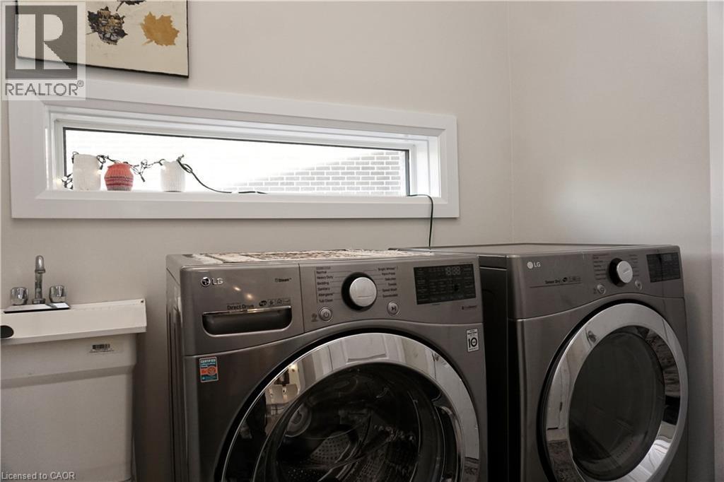 Laundry area featuring a utility sink with a chrome faucet and a horizontal window - 63 Ian Ormston Drive, Kitchener, ON - Indoor Photo Showing Laundry Room