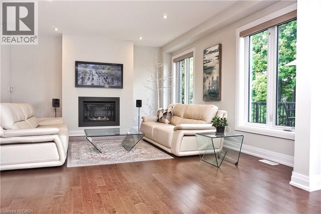 Living area featuring hardwood flooring, a fireplace with a dark surround, and recessed lighting - 63 Ian Ormston Drive, Kitchener, ON - Indoor Photo Showing Living Room With Fireplace